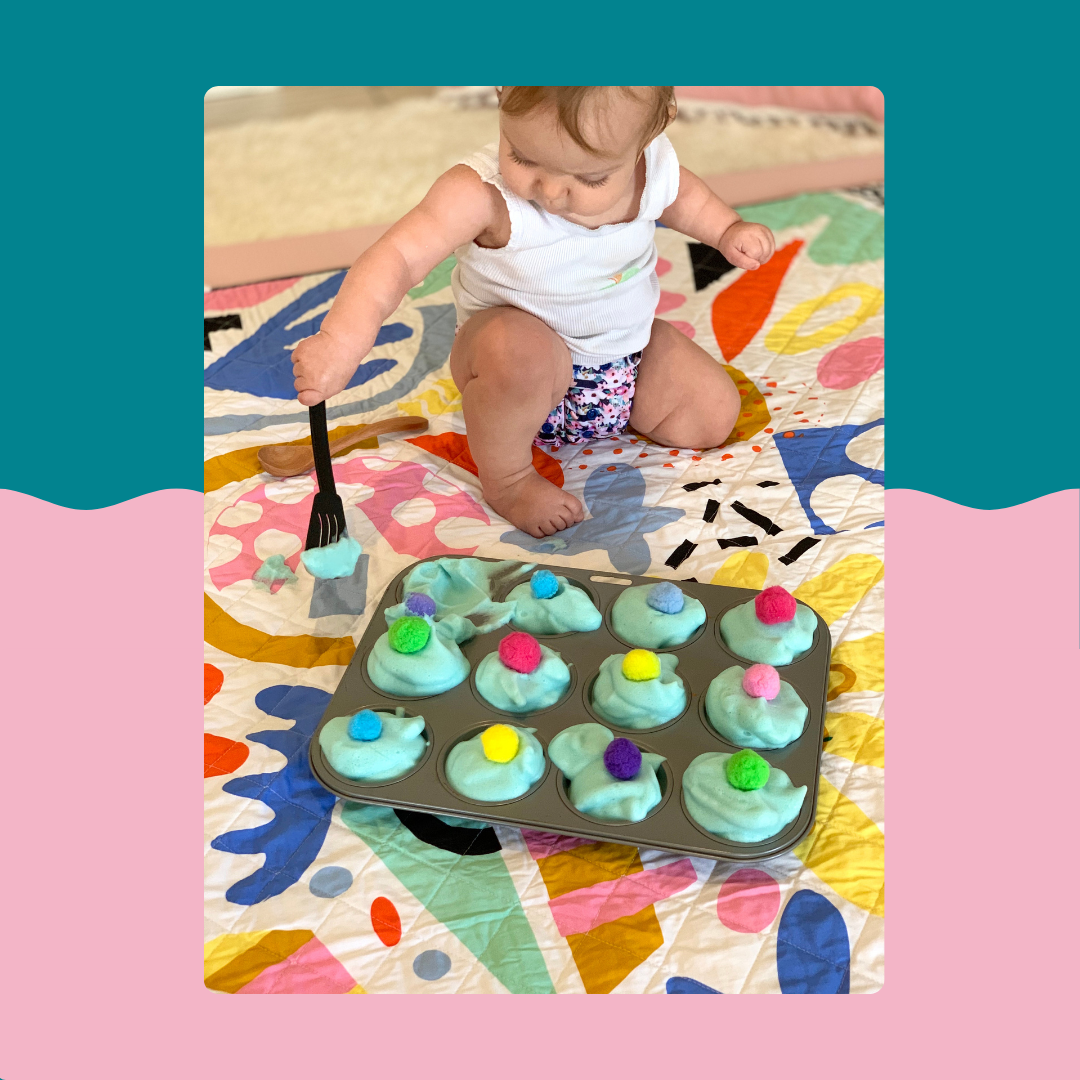 baby on colourful rudie nudie play mat playing with muffin tin during nappy free time