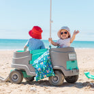 hola mamacita wet bag hanging on a beach wagon with two toddlers