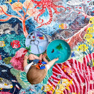 overhead view of a baby doing sensory play on the octopus's garden waterproof picnic blanket