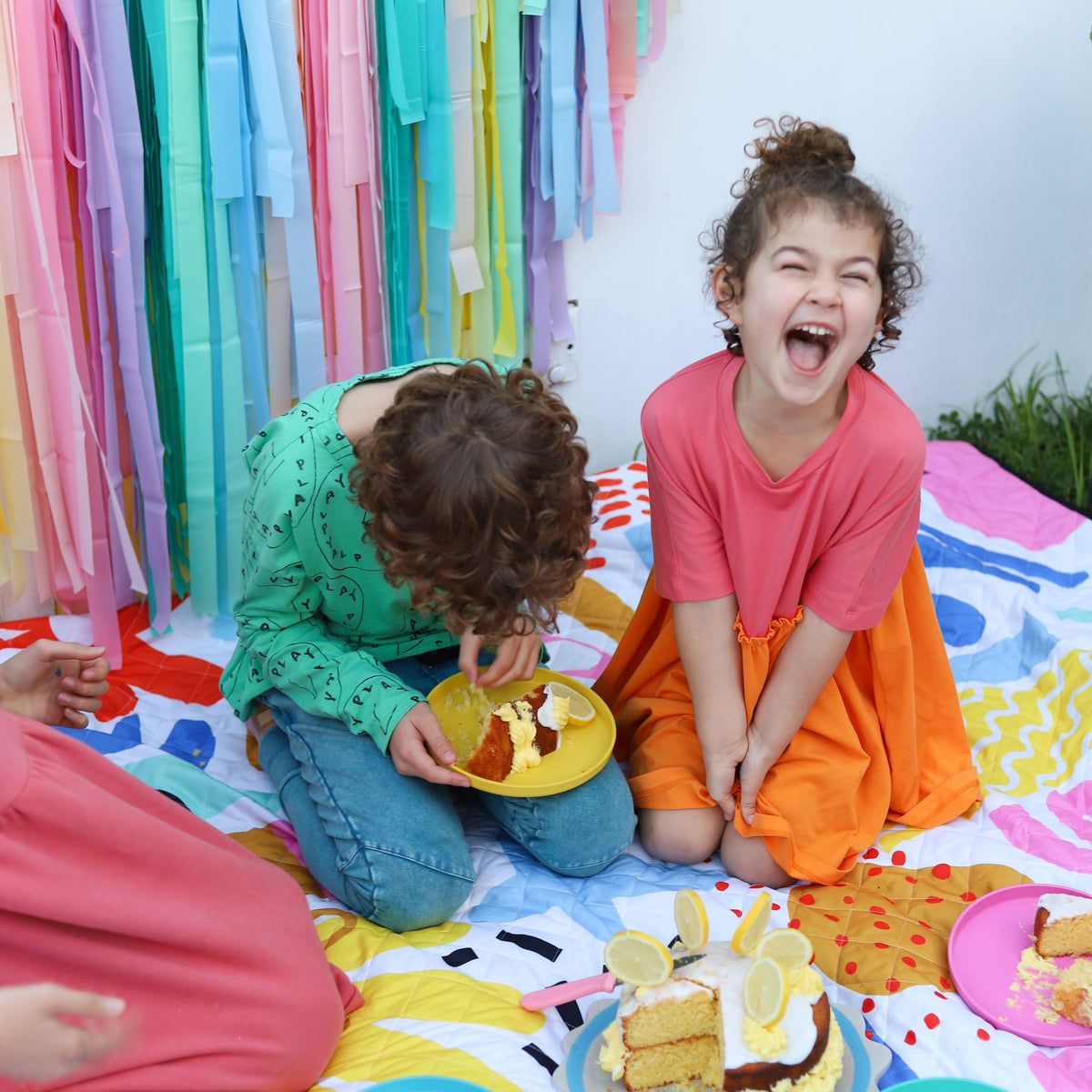 two children laughing with birthday cake on the pop pip pow waterproof picnic blanket