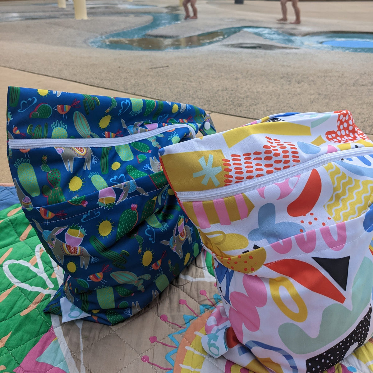 pop pip pow wet bag and hola mamacita wet bag at a splash park