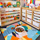 the happy now large waterproof playmat set up with a sensory tray in a bright playroom